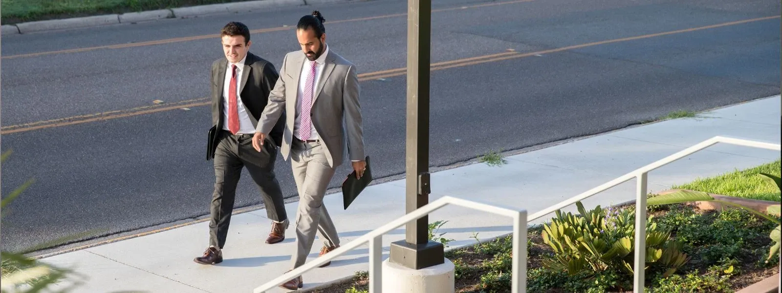 Business students in professional attire walking down sidewalk